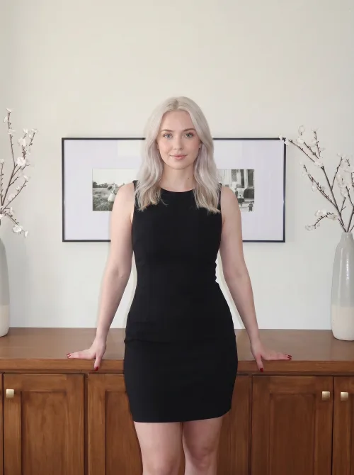 Made on Blogent: minimalist interior portrait, blonde woman in a little black dress in a bright gallery room, framed prints, natural…
