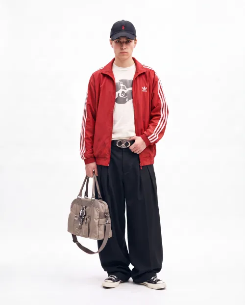 Made on Blogent: full-body streetwear look, model in a red track jacket and wide trousers with a designer bag, seamless studio backdrop…