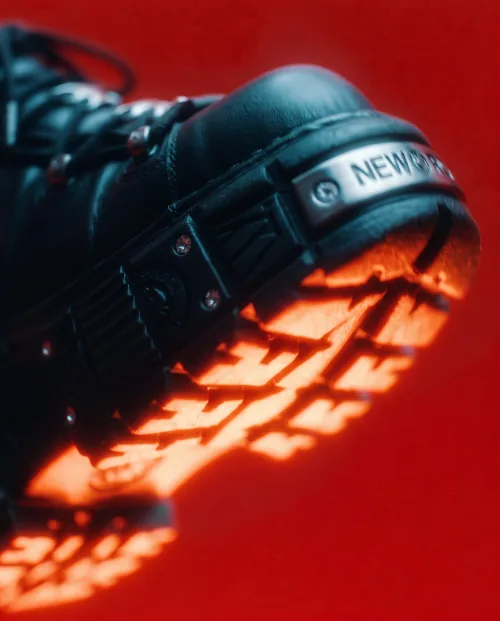 Made on Blogent: dramatic product hero, a sneaker lit with deep red light and long sculptural shadows, high contrast, advertising…